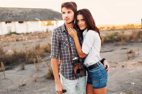 Casal casual posando ao ar livre ao pôr do sol — Fotografia de Stock