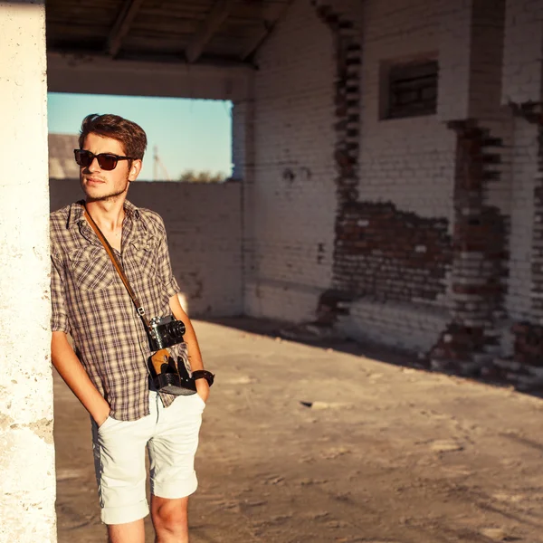 Homem com câmera vintage posando ao ar livre — Fotografia de Stock