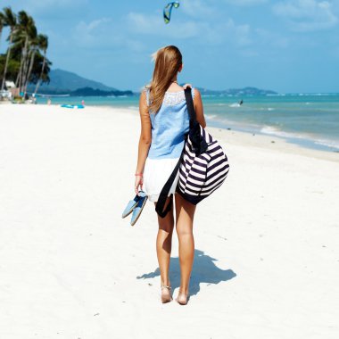 Sahilde, sırt çantası kadınla arkadan görünüm