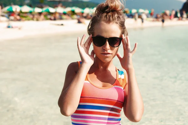 Bronzé femme blonde dans des lunettes de soleil sur la plage — Photo