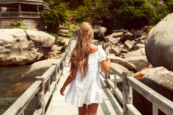 Mulher de vestido branco andando no cais — Fotografia de Stock