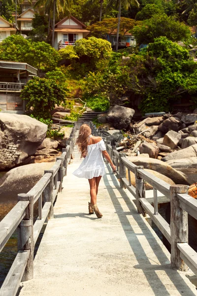 Жінка в білій сукні, що йде на пірсі — стокове фото