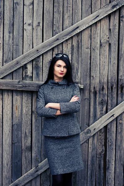 Brunette vrouw die zich voordeed op houten achtergrond — Stockfoto