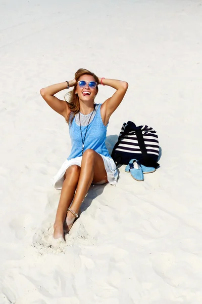 Vrouw in zonnebril met rugzak en schoenen op zand — Stockfoto