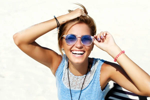 Femme souriante avec des lunettes de soleil bleues — Photo