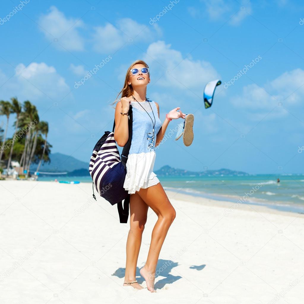 woman with backpack posing on the beach
