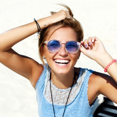 içinde mavi güneş gözlüğü gülümseyen kadın