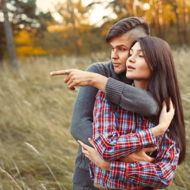 Adam kız arkadaşına bir şey gösteriyor.