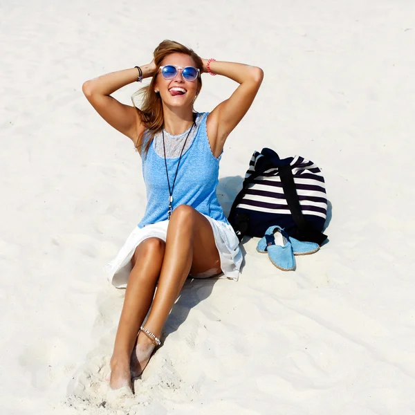 Vrouw in zonnebril met rugzak en schoenen op zand — Stockfoto