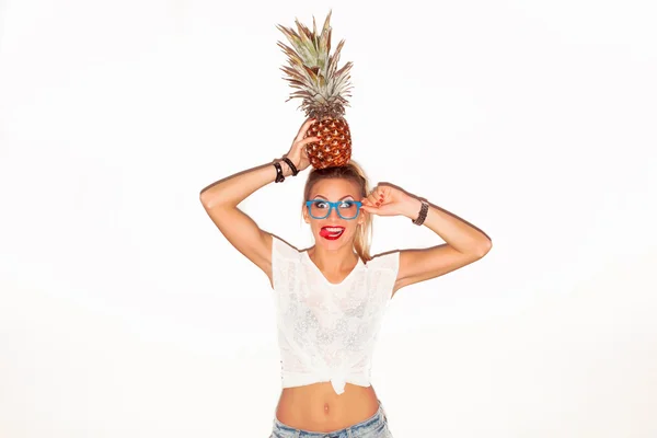 Woman in glasses with pineapple showing tongue — Stockfoto