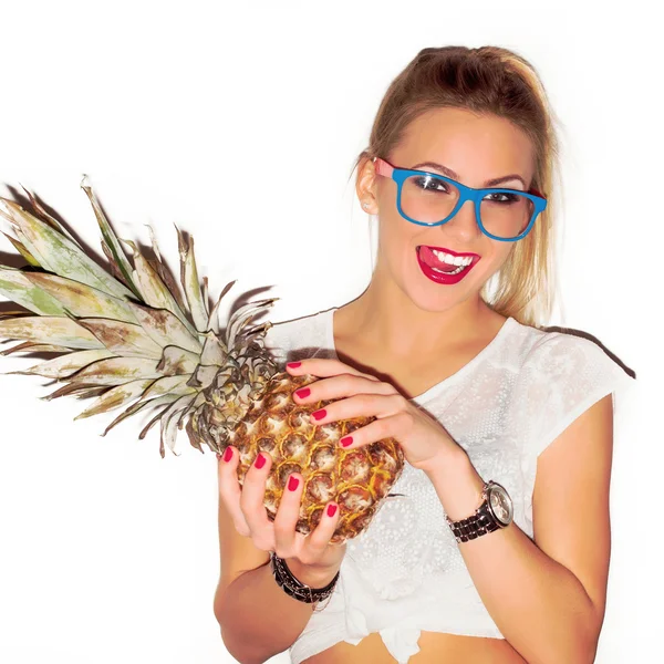 Woman in glasses with pineapple showing tongue — Stock fotografie