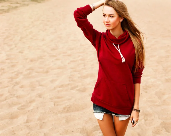 金发女人，在海滩上的红毛衣 — 图库照片