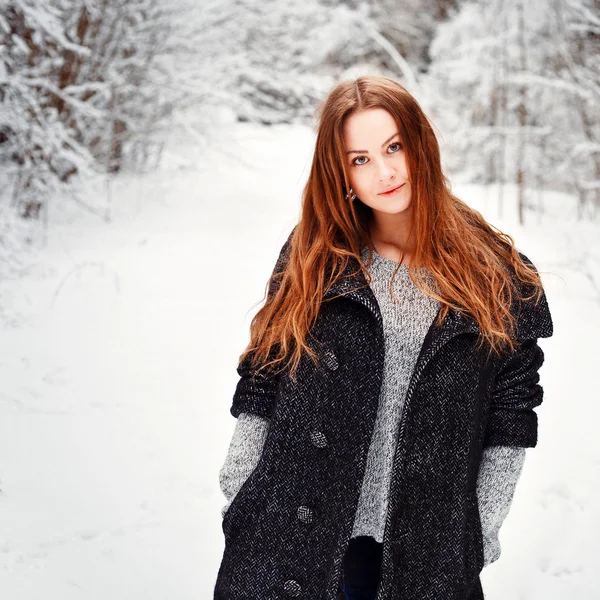 Молодая женщина позирует в зимнем лесу — стоковое фото