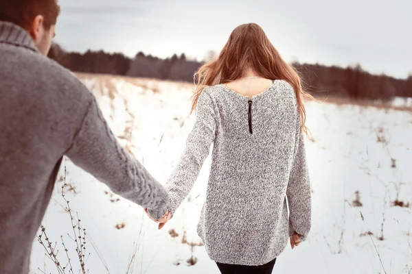 Jovem casal caminhando no campo de inverno — Fotografia de Stock