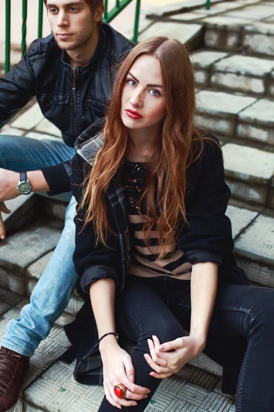 Fashion couple sitting outdoor on steps — Stock Photo, Image