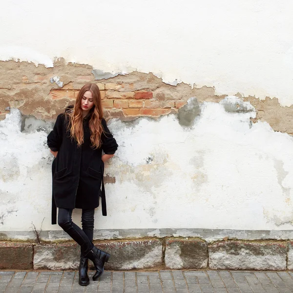 Femme en manteau près du vieux mur — Photo