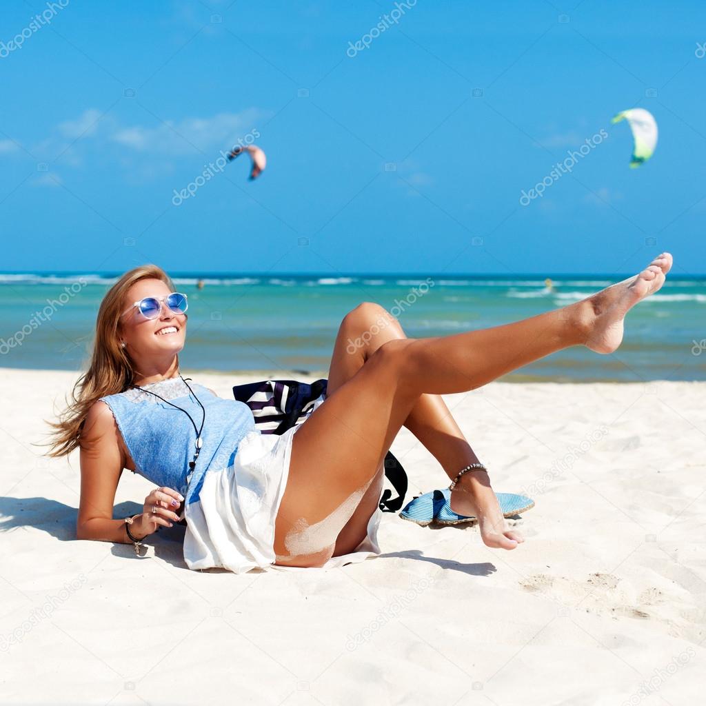 Woman with sexy tanned legs on the beach Stock Photo by ©SolominViktor  96660176