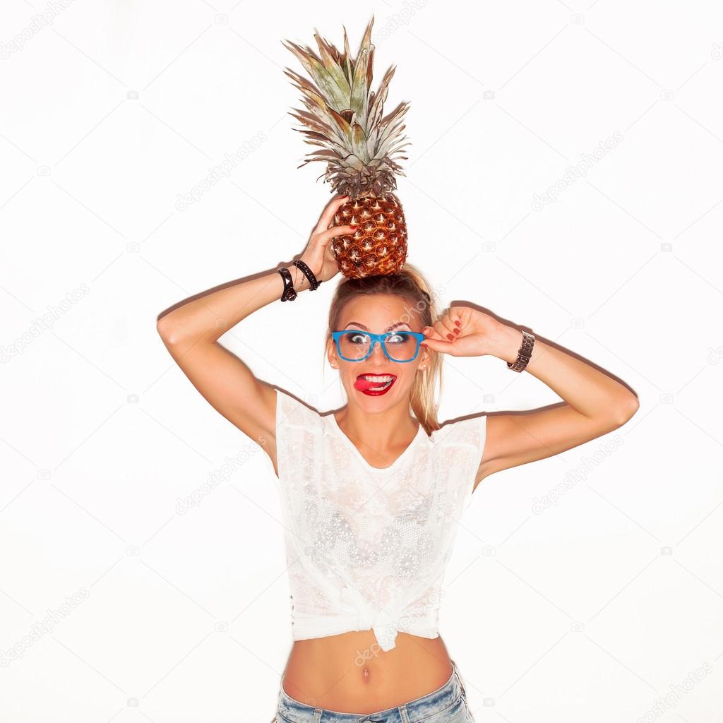 woman in glasses with pineapple showing tongue