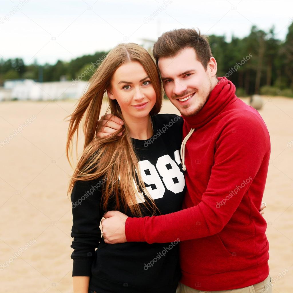 young couple in love posing on the beach