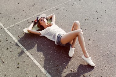 girl lying on the ground with skateboard and dreaming