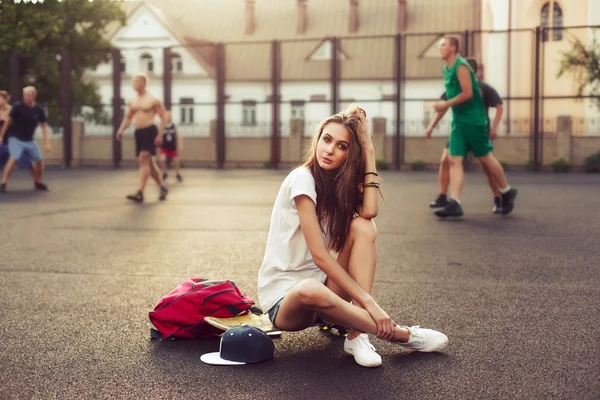 Дівчина з скейтбордом і рюкзаком. Хіпстерський спосіб життя — стокове фото