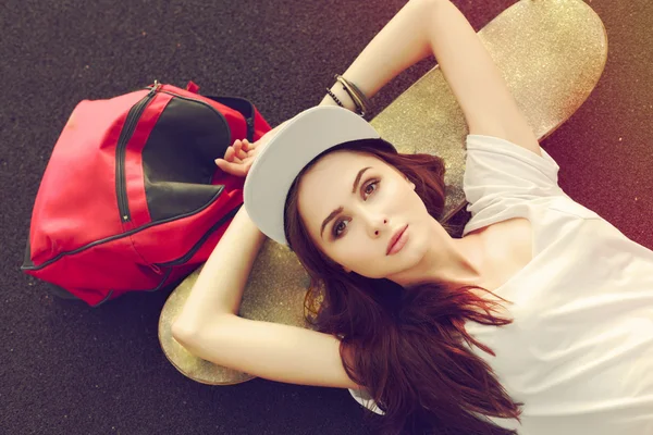 Sensual menina deitada no chão com skate — Fotografia de Stock