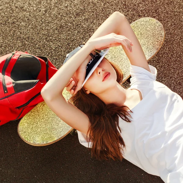 Хипстерская девушка со скейтбордом и рюкзаком . — стоковое фото