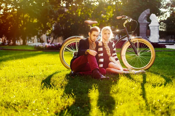 年轻的时髦夫妇与自行车在公园。 — 图库照片