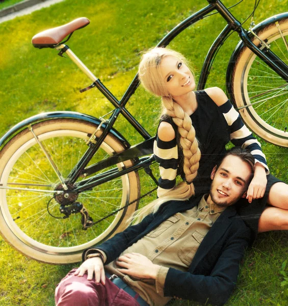 Jovem casal hipster com bicicleta no parque — Fotografia de Stock