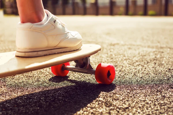 Longboard com rodas vermelhas e menina — Fotografia de Stock