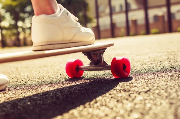 Longboard mit roten Rädern und Mädchen — Stockfoto