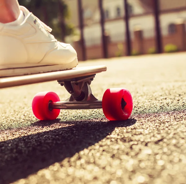Longboard com rodas vermelhas e menina — Fotografia de Stock