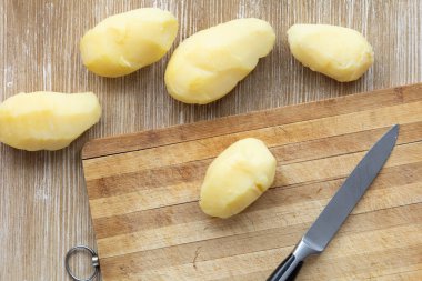 Ahşap arka planda, ceketle fırçalanmış haşlanmış patateslerin üst görüntüsü