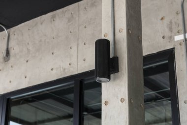 Evin önündeki beton direkte siyah lambalar..