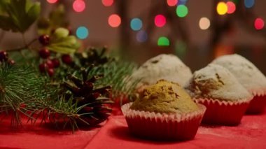 Çam kozalaklı Noel gözlemeleri ve arkasında Noel ışıkları olan doğal çam dalı.