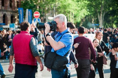 Ermenistan, Erivan, 23 Nisan 2018 - Kadife devrim sırasında Erivan, Cumhuriyet Meydanı 'nda yabancı bir fotoğrafçı deomnstratörleri vuruyor
