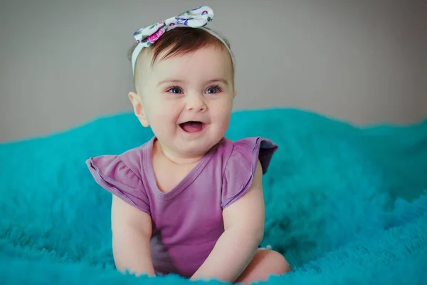 可愛いです赤ん坊とともに紫ドレス見ます彼女のお母さんと座っています彼女のベッド — ストック写真