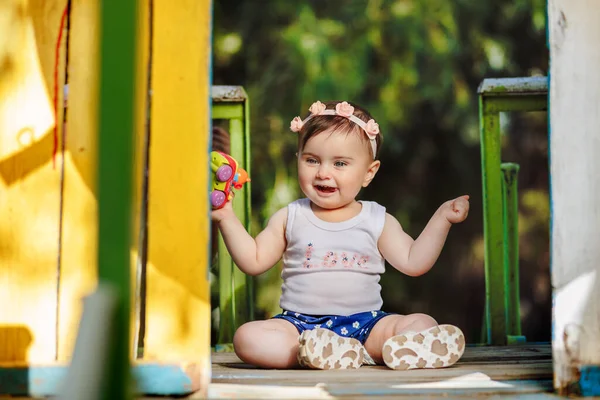 可爱的八个月大的婴儿在操场上笑着拿着她的玩具 — 图库照片