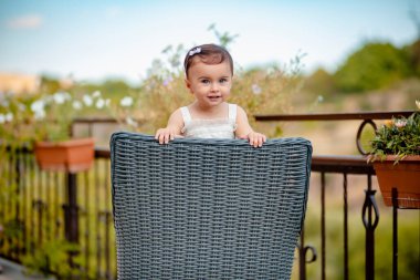 Harika mavi gözleri olan, saman sandalyeye çıkıp gülümseyen hayret verici bir bebek.