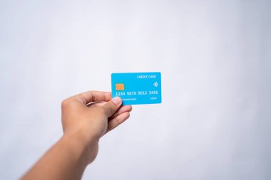 Elinde açık mavi bir kredi kartı var.