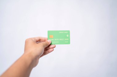 Elinde yeşil bir kredi kartı var.