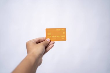 Elinde turuncu bir kredi kartı var.