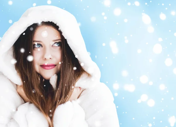 Beyaz kapüşonlu kürk giyen genç bir kadının Noel ve kış tatili portresi, mavi arka planda kar, moda ve yaşam tarzı — Stok fotoğraf