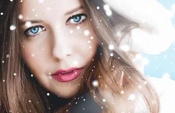 Kerst en winter vakantie portret van jonge vrouw in witte capuchon bontjas, sneeuw op blauwe achtergrond, mode en levensstijl — Stockfoto