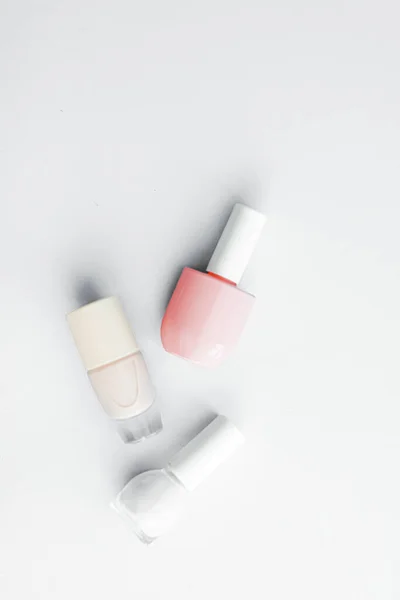 Beyaz arka planda tırnak cilası şişeleri, güzellik markası — Stok fotoğraf