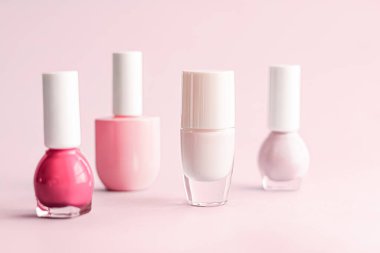 Tırnak cilası şişeleri pembe arka planda, güzellik markası