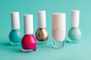 Yeşil arka planda oje şişeleri, güzellik markası.