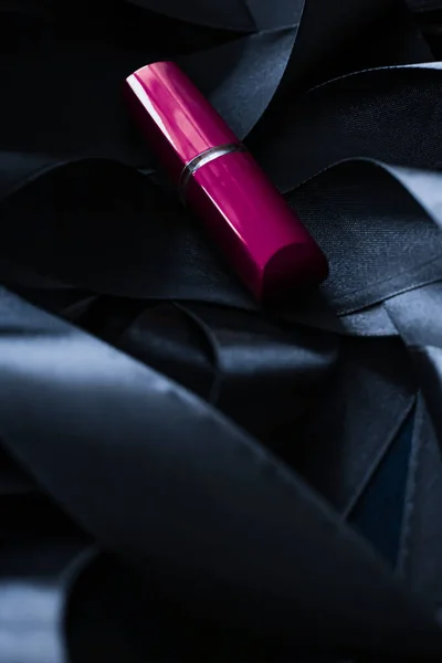 Lápiz labial púrpura sobre fondo de seda negro, maquillaje de lujo y cosméticos de belleza — Foto de Stock