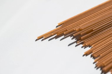 Kahverengi çiğ tahıllı spagetti, organik gıda malzemesi olarak İtalyan makarnası, makro ürün ve yemek kitabı tarifi.