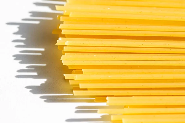 Closeup de espaguete de grão integral não cozido, massas italianas como ingrediente alimentar orgânico, macroproduto e receita de livro de cozinha — Fotografia de Stock